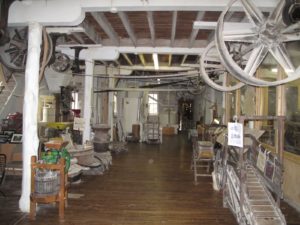 This is an inside view of the mill which exhibits a lot of old machinery and tools.