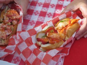 A classic Maine lobster roll on the left and a Connecticut roll on the right - served on a buttered roll
