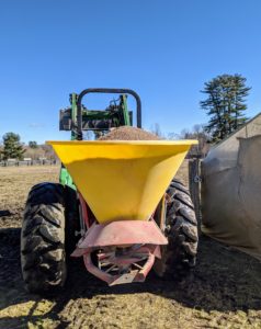 Here is the spreader, which is hitched to the back of the tractor. It moves the pulverized limestone and throws it about 30 feet out as it is driven through the field.