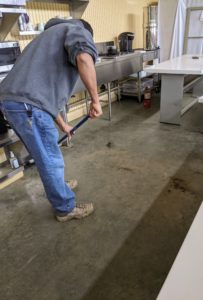 First, Carlos thoroughly sweeps the concrete floor of any dust and dirt. Because this area can get dusty, Carlos works from the bottom up, so all the eating surfaces are cleaned last.