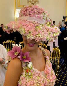 Floral "fairies" delighted guests with their fanciful floral attire. This Elan Artists model was dressed in “fresh floral” fashion designed by Holly. The larkspur hat and gown are accented with hellebores, Pieris, and ranunculus.