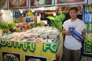 A seafood vendor with a welcoming and colorful shop