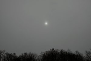 The sun is trying to be seen through the heavy cloud cover.