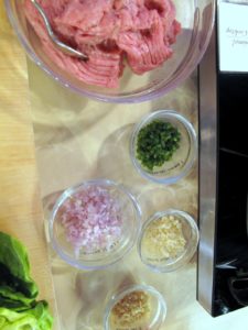 The ingredients for stir fried turkey in lettuce wraps, including lean ground turkey, chopped jalapeno, shallot, garlic, and ginger.