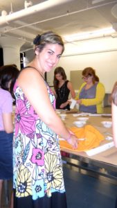 Here, Francesca who attends Georgetown University and is a Corporate IT Intern, is placing cupcake stencils on her apron.