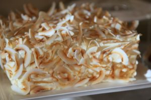 A rich coconut cake with toasted coconut shavings