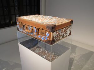 A suitcase highly decorated with mirrors.