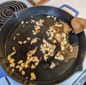 In a skillet over medium-high heat, Cheryl toasts the almonds in a tablespoon of oil.