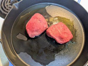 The steaks are patted dry and seasoned all over with salt and pepper and then cooked in a medium heavy skillet over medium-high heat.