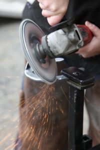 A grinding wheel smooths out the edges.