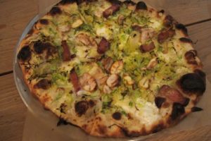 Brussels Sprout Pie with shaved brussels sprouts, béchamel, parmesan, mozzarella, lardons, chestnuts, red onion, and chili flakes
