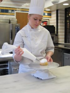 A student practicing her pastry bag skills