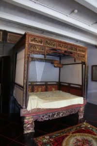 This is a sumptuously carved, lacquered, and gilded canopied wedding bed from 19th-century Penang.
