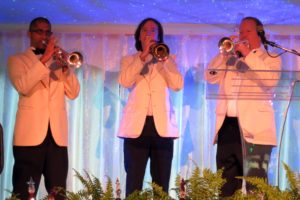 Three vibrant trumpets announced that the concert would begin shortly.