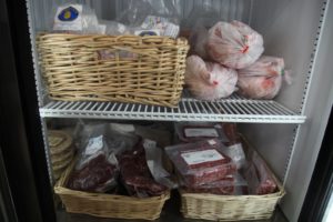 A freezer contains locally raised chicken, beef, lamb, and pork.