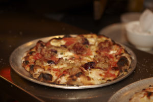 Pizza Boscaiola with tomato, mozzarella,
pork sausage, mushroom,  onion, and chili