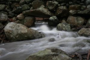 The stone wall has been there for many, many years and was obviously built to accommodate the flowing water.