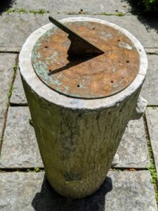 At the end of the footpath is this antique sundial. A sundial is any device that uses the sun's altitude or azimuth to show the time. It consists of a flat plate, which is the dial, and a gnomon, which casts a shadow onto the dial.