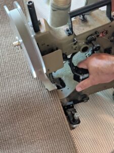The machine is equipped with little wheels so it can be pulled along as it sews, making a very neat edge.