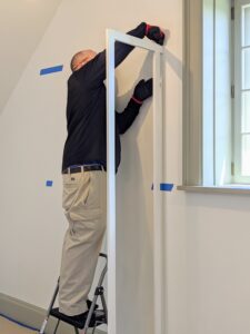 First, Brandon secures the brackets to the wall. These supports will keep the piece upright and well-anchored. These uprights sit one-inch away from the back wall to allow for baseboards, outlets, and uneven wall textures.