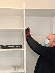 In a couple hours, Brandon has most of the shelving complete. The piece focuses on open shelving, so it looks clean and has an easily-accessible design for visibility as well as function.