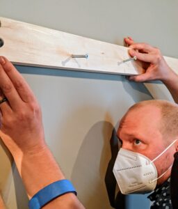 Measuring is the most important step, so David makes sure everything is just right before screwing it into the wall completely.