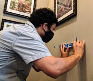 Carlos works on the mushroom prints on the wall by my back stairwell.