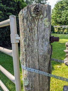 The two cedar uprights holding the gate were quite wobbly. For a quick fix some time ago, we secured perforated metal strips to keep the post in place, but now it was time to replace the wood completely.