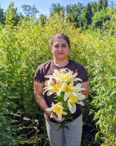 My housekeeper, Enma, is in the flower garden, She also picks those lilies growing in the back or behind taller plants. Here she is with a bunch of light yellow blossoms.