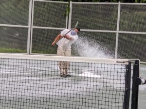 The next step is to spread calcium chloride across the court. Calcium chloride is a dissolving salt that retains moisture in HAR-TRU court surfaces.