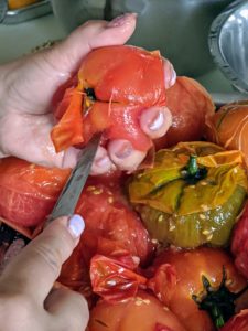 Enma takes each tomato and hand peels the skins – boiling them really helps. And then she hulls the leftover parts of the stem at the top of each tomato.