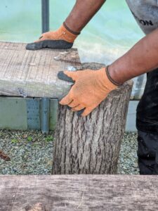 Each of these log sections weighs more than 150-pounds, so it takes a lot of elbow grease to get all of them in place. Here, Pasang centers the log, so that the ends of the planks rest securely on top.