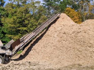 A continuous discharge conveyor carries the material away from the machine and piles it up in a mound.
