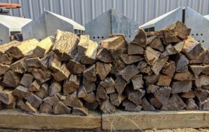 A pile of firewood logs are already split and stored in this space.