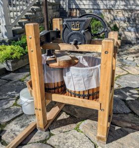 I've had this manual press for about 10 years. It is designed to grind and squeeze at the same time. This "American Harvester" model consists of a hand-crank grinder affixed to a basket press. The grinder, pressing screw, and flywheel crank are all made of durable cast iron.