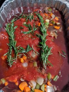 This is Torrey's short ribs dish - it's always a big request for the holidays. Before cooking, he marinates them for two days with tomatoes, rosemary, celery, and carrots, then slow cooks them. The tender meat is pulled off the bone and served with the sauce.