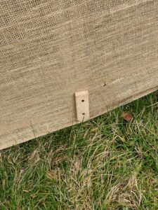 It looks very tidy once attached. Both the metal and wood stakes can be seen through the fabric.