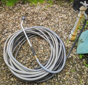 At the back of the greenhouse is one of our long Gilmour hoses, neatly coiled and ready to use. I have been using Gilmour products for years. The Gilmour 50-foot and 100-foot Flexogen hoses are heavy-duty eight-ply garden hoses with a polished surface that resists abrasions, stains, and mildew.