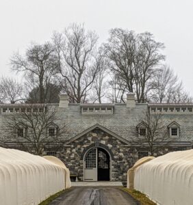 Here is a view of the stable from the long Boxwood Allee now covered in burlap for the winter. Looking above, the sky is completely covered in clouds.