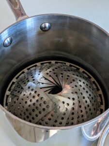 These stainless steel expandable steamer baskets are easy to find. This is my Martha Stewart steamer basket from Macy's. The flaps collapse or open to fit various pots and pans.