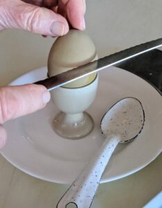 To serve eggs in their shells, I use the edge of a serrated knife to cut off the top.