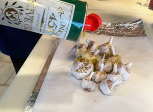 Next, I drizzle the garlic with olive oil and season with salt and pepper to taste.