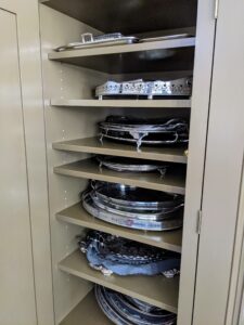 In between all these stacked silver trays is a piece of felt - one can be seen on the lower shelf. Placing these layers of felt prevents any scratches or scuffs. And felt is easy to find at fabric stores.