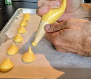 Chef Pierre also made gougères. A gougère, in French cuisine, is a baked savory choux pastry made of choux dough and mixed with cheese. The cheese is commonly grated Gruyère, Comté, or Emmentaler. These are always a big hit to serve before the main meal.