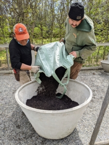 Phurba and Brian fill about half of the container with nutrient-rich compost made right here at the farm.