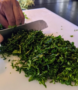 For the main dish, I chose to serve Selle 'D'Agneau or Saddle of Lamb. Pierre's sous chef, Moises, chops up the herbs for the Selle D'Agneau. All these herbs were grown right here in my garden. Look how green this parsley is - and it smells so wonderfully fresh.