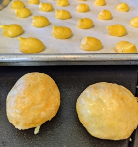 Look how the gougères puff up after cooking. The secret to gougères' puff is the addition of eggs - too many eggs and the dough will be too wet to properly puff. It's also best to use dry cheeses - they puff best.