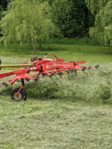 Here is another view – look how the tedder picks up and fluffs the hay with its forks.
