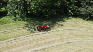 After the hay is tedded, it is then raked. Raking the hay is the fastest part of the process. There are different kinds of rakes - they include wheel rakes, rotary rakes and parallel bar or basket rakes. This is a parallel bar rake. This type uses a gentle raking action with a lower chance of soil contamination than the wheel rake.