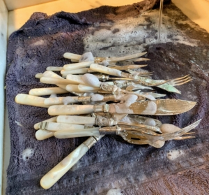 The same is done for these silver knives with mother of earl handles. Mother-of-pearl, nacre, is a glowing, pearlescent material that's used to make flatware handles, jewelry and ornaments. Mother-of-pearl comes from the inside of oyster and abalone shells.